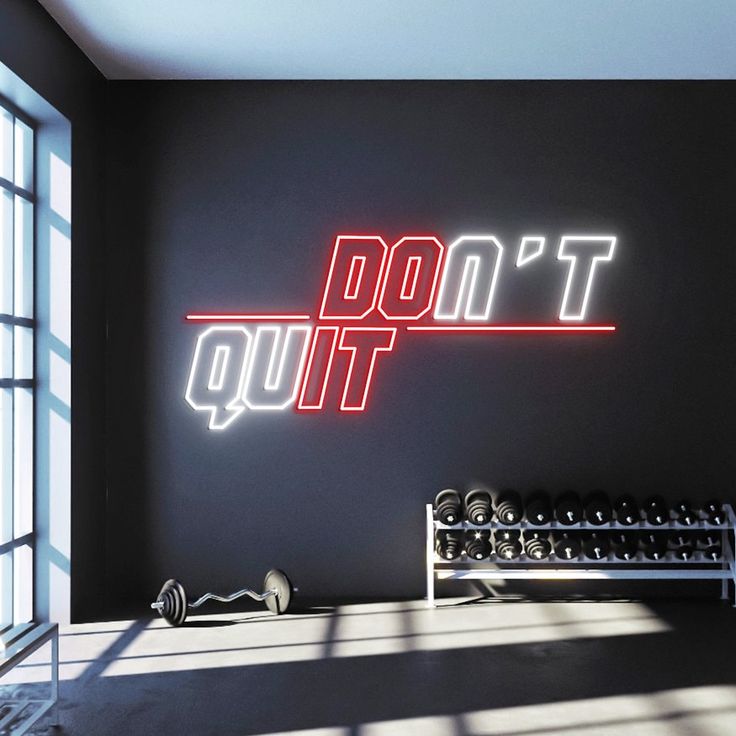 A red and white gym neon sign with the motivational phrase 'don't quit'