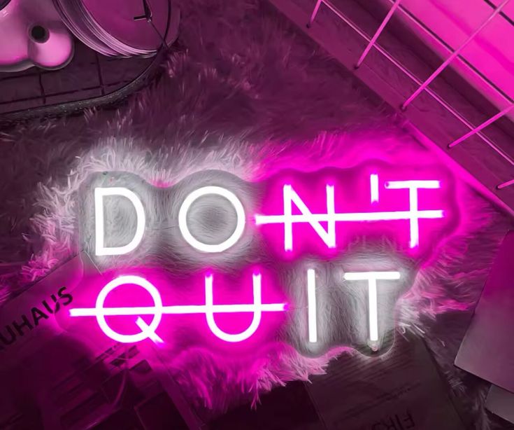 Gym neon sign with the phrase 'Don't quit' in pink and white.