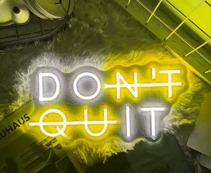 Gym neon sign with the phrase 'Don't quit' in yellow and white.