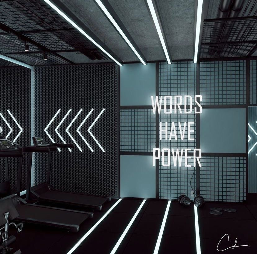 A vibrant gym neon sign with a bold statement 'words have power' in white neon