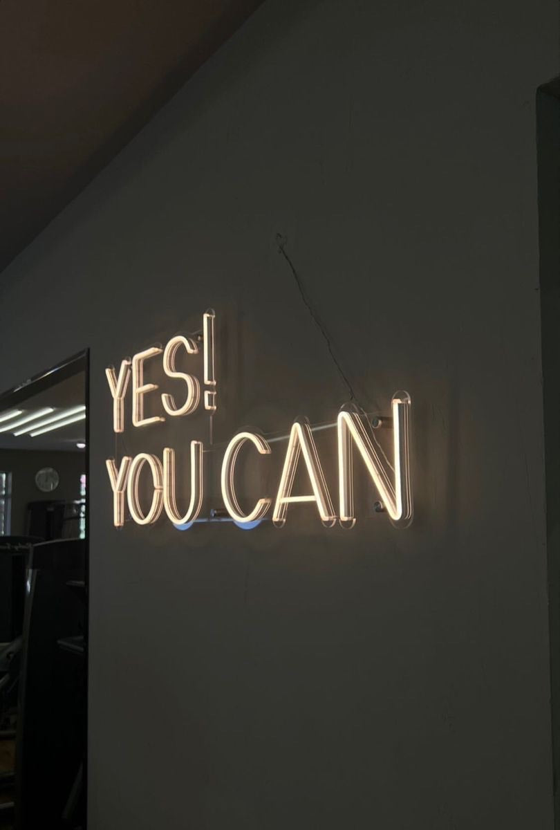 Motivational gym neon sign with the phrase 'YES YOU CAN' in a warm neon glow