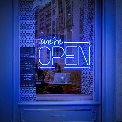 A vibrant blue neon sign displaying the message "We're Open" in bold letters. Ideal for cafes, restaurants, and shops, this sign provides clear and inviting illumination.