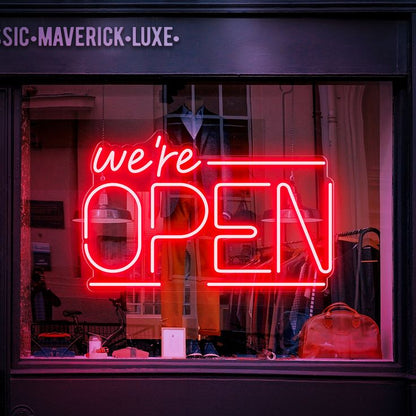 A vibrant red neon sign displaying the message "We're Open" in bold letters. Ideal for cafes, restaurants, and shops, this sign provides clear and inviting illumination.