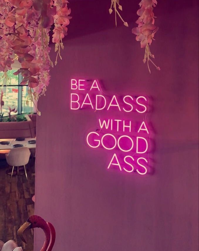 Vibrant 'Be a Badass with A Good Ass' neon sign, ideal for enhancing gym decor and women only gyms