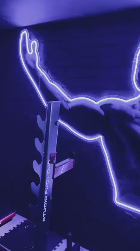 Black and white Neon sign cut out of Arnold Schwarzenegger in a gym with cool lights